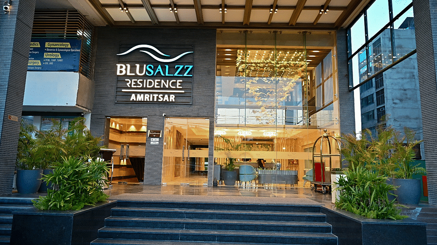 Hotel entrance with neatly arranged plants on both sides at BluSalzz Residence, Amritsar.